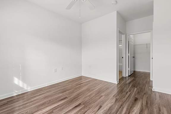 A room with a ceiling fan and wooden flooring.