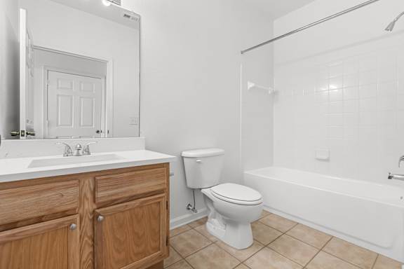 A white bathroom with a toilet, sink, and bathtub.