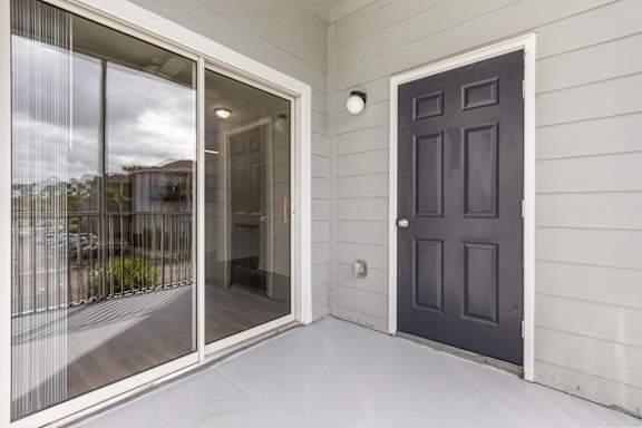 A black door is on the right side of a white wall.