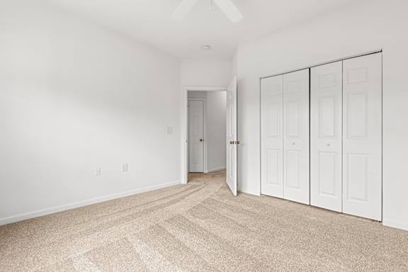 A room with a carpeted floor and a white door.