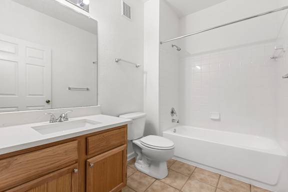 A white bathroom with a toilet, sink, and bathtub.