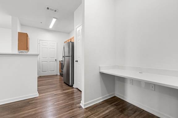 A kitchen with a refrigerator and a counter.