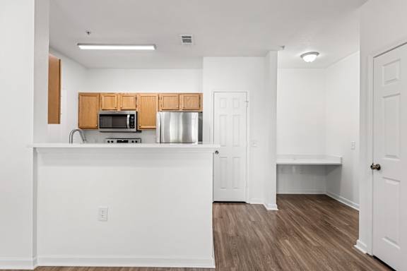 A kitchen with white cabinets and a white counter.
