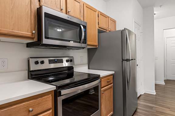 A kitchen with a black refrigerator, stove, and microwave.