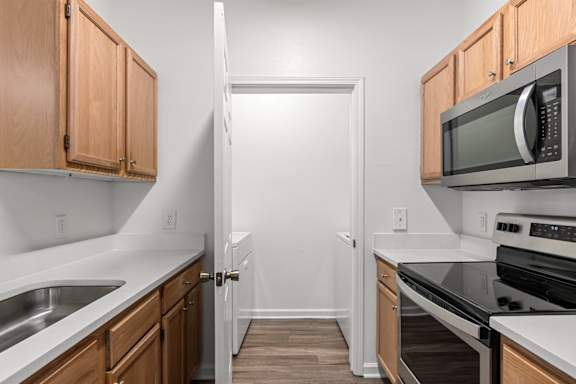 A kitchen with wooden cabinets and a white counter top.