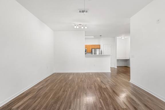 A room with wooden flooring and white walls.