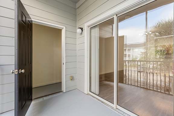 A black door is open to a balcony.