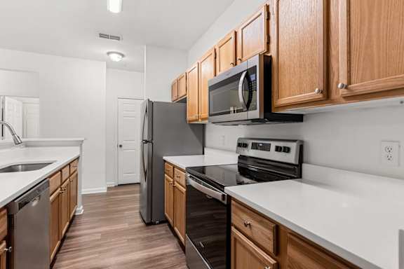 A kitchen with wooden cabinets and black appliances.