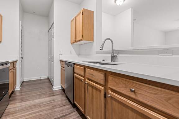 A kitchen with wooden cabinets and a white countertop.