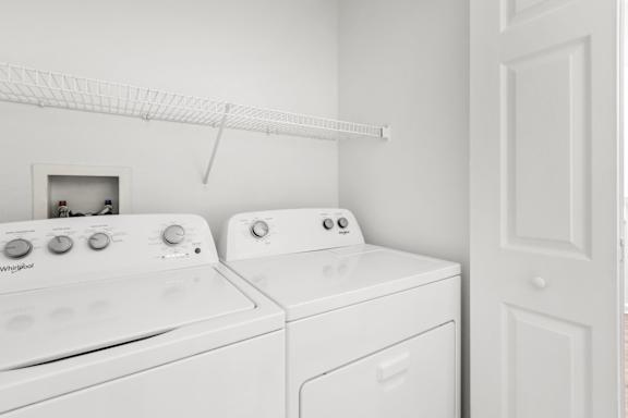A white washing machine and dryer in a laundry room.