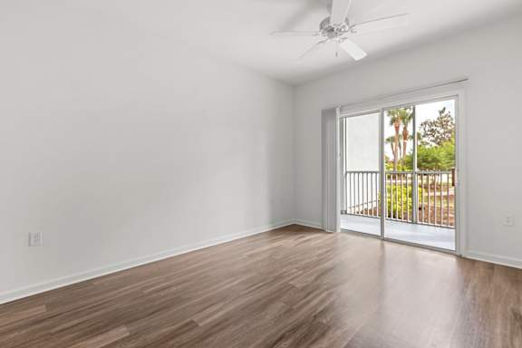 A room with a sliding glass door leading to a balcony.