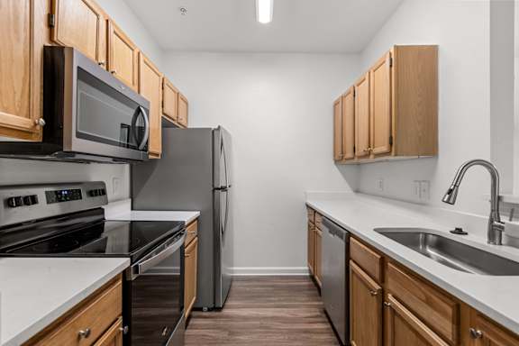 A kitchen with wooden cabinets and stainless steel appliances.