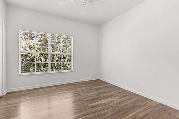 A room with a window and a ceiling fan.