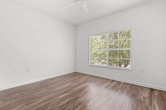 A room with a window and wooden flooring.