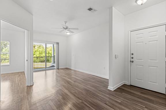 A room with a sliding glass door leading to a balcony.