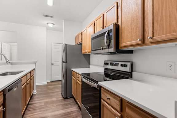 A kitchen with wooden cabinets and black appliances.