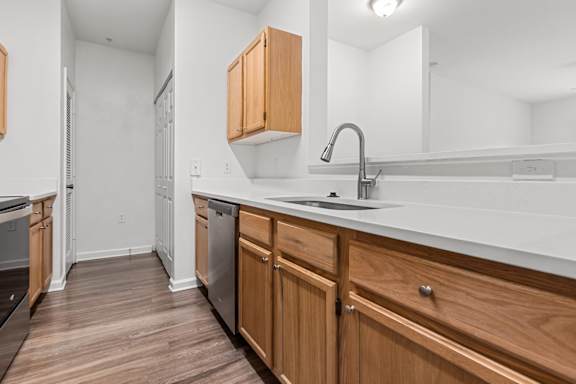 A kitchen with wooden cabinets and a white countertop.