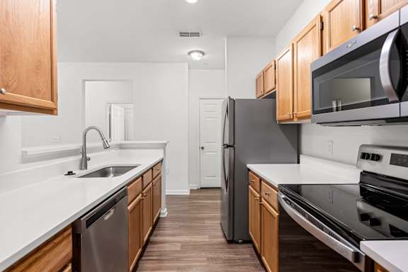 A kitchen with wooden cabinets and stainless steel appliances.