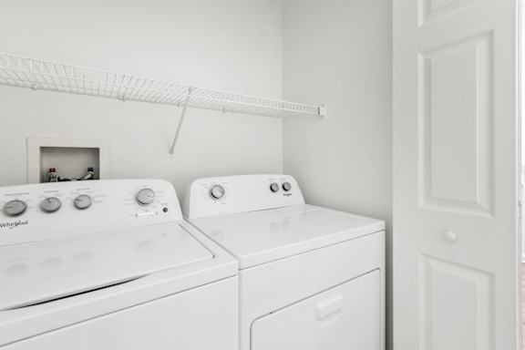 A white washing machine and dryer in a laundry room.