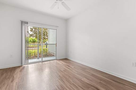 A room with a sliding glass door leading to a backyard.