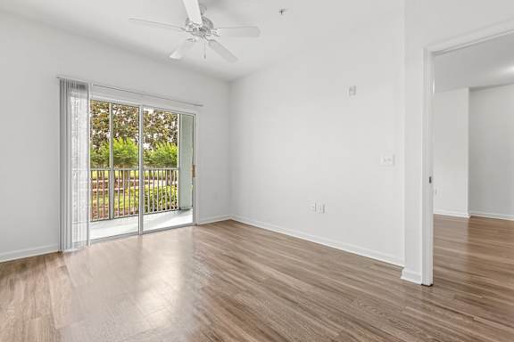 A room with a sliding glass door leading to a balcony.