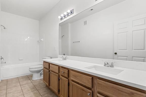 A white bathroom with a toilet, sink, and tub.