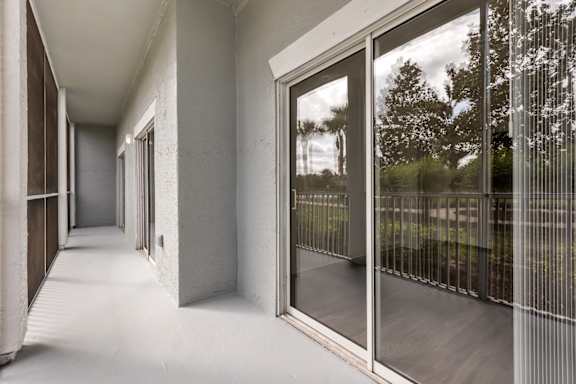 A long hallway with a glass door on the end.