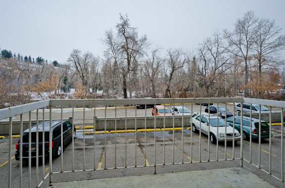 A parking lot with cars and a metal fence.