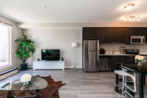 A modern kitchen with a refrigerator, microwave, and oven.