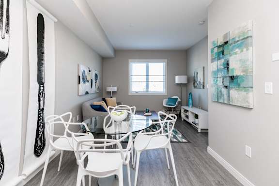 A dining room with a white table and chairs.