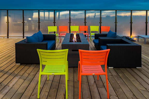 A set of brightly colored chairs are arranged on a deck.