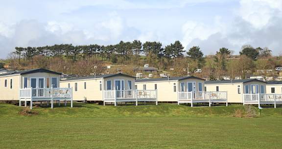 Floor Plan  A row of mobile homes are lined up in a field.