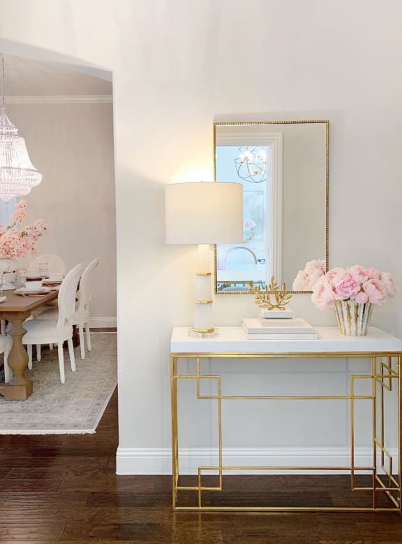 a white desk with a mirror and a table in a room