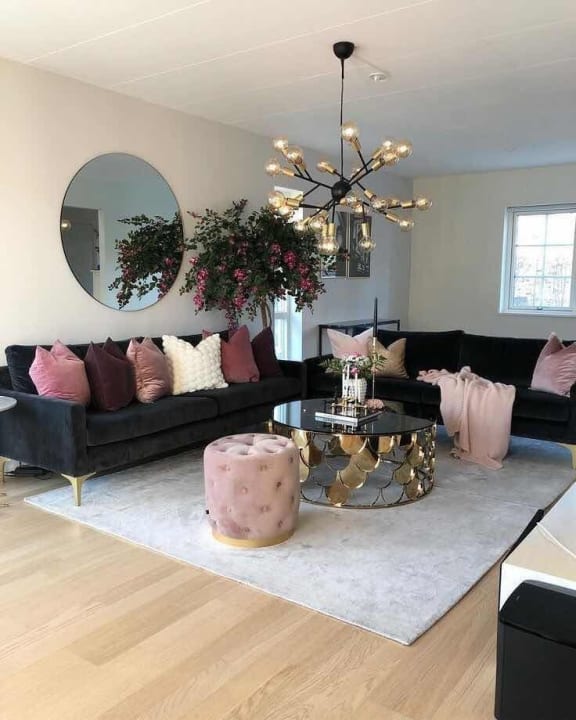 a living room with black furniture and pink pillows