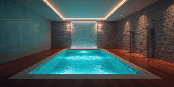A small indoor swimming pool with a waterfall feature.