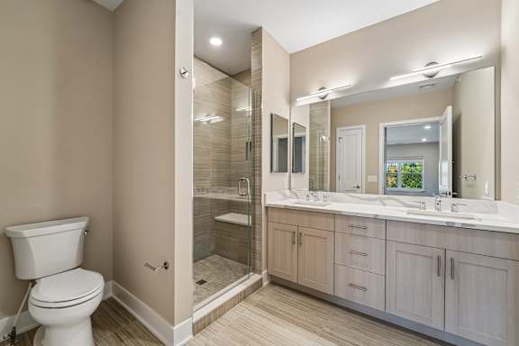 A bathroom with a toilet, sink, and mirror.