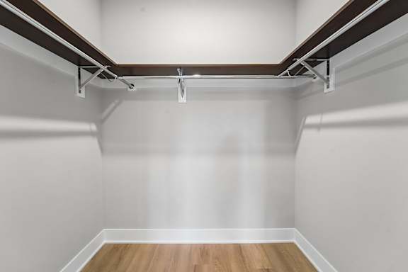 A white wall with a wooden floor and a brown ceiling.