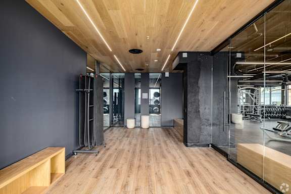 A gym with wooden floors and mirrors on the wall.