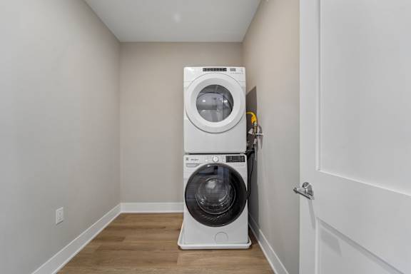 A white washing machine and dryer in a small, empty room.