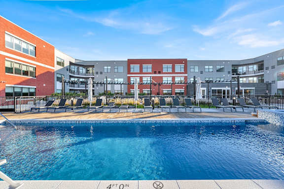 A swimming pool in front of a multi-story building.