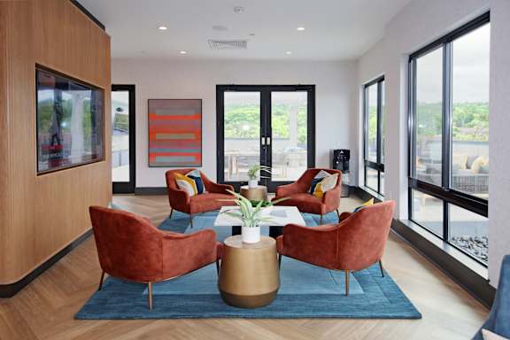 A living room with a blue rug and red chairs.