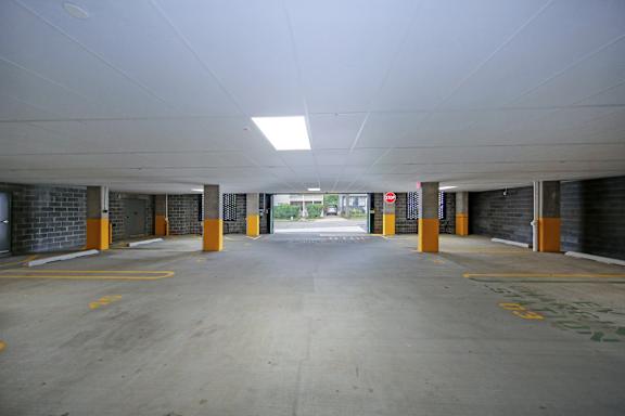 A parking garage with yellow lines and orange posts.