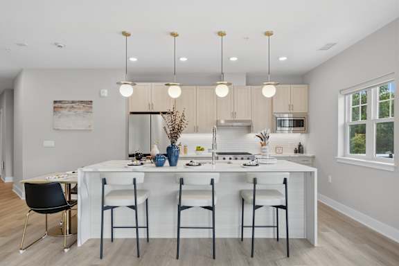 A modern kitchen with a dining table and chairs.