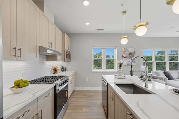 A modern kitchen with a large island and a view of the backyard.