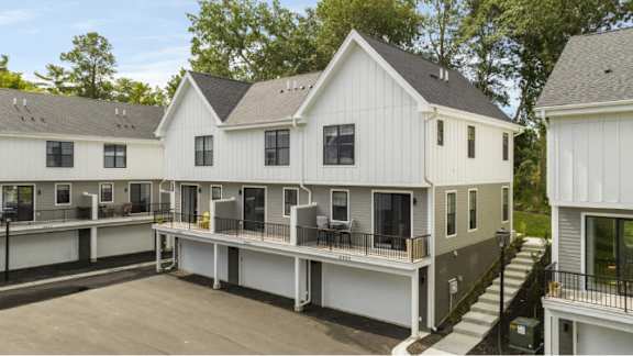 A row of white houses with black railings and windows.