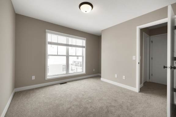 A room with a carpeted floor and a window.