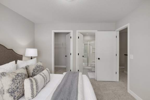 A bedroom with a bed, a lamp, and a mirror.
