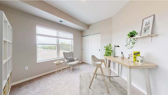 A room with a white chair, a white desk, and a white shelf with plants on it.