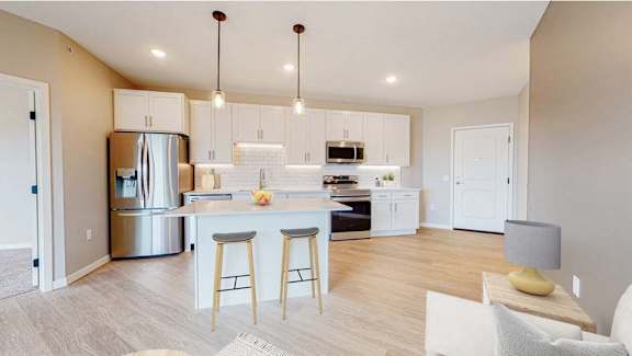 A modern kitchen with a bar area and a dining table.