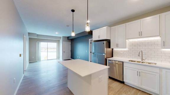 A kitchen with white cabinets and a large island.